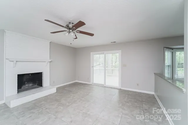 a view of empty room with fan and fireplace
