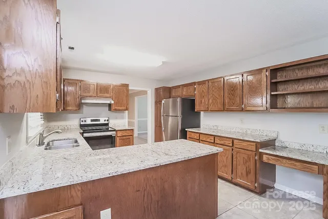 a kitchen with stainless steel appliances a sink stove and refrigerator