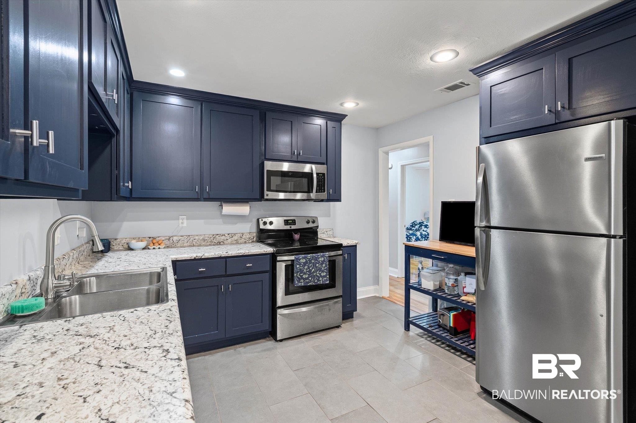 5609 Diane Court Mobile, AL 36618 - Photo 6 of 22 Kitchen with appliances with stainless steel finishes, recessed lighting, blue cabinets, light tile patterned flooring, and light stone countertops