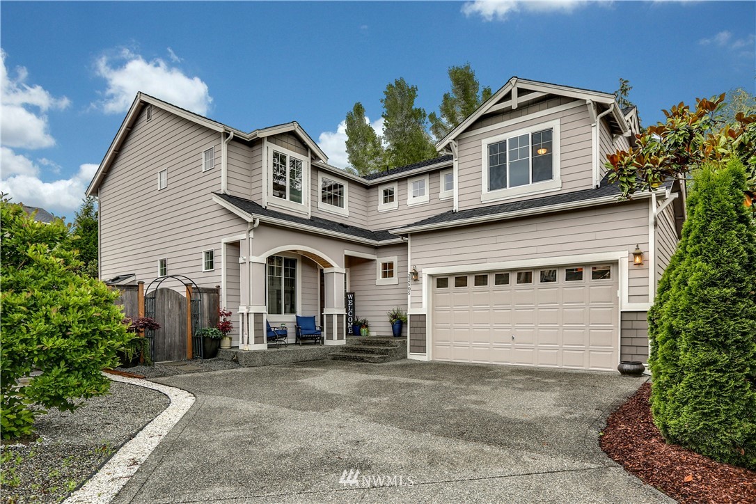 22505 38th Avenue Southeast Bothell, WA 98021 - Photo 2 of 39 a view of a white house with large windows and a small yard