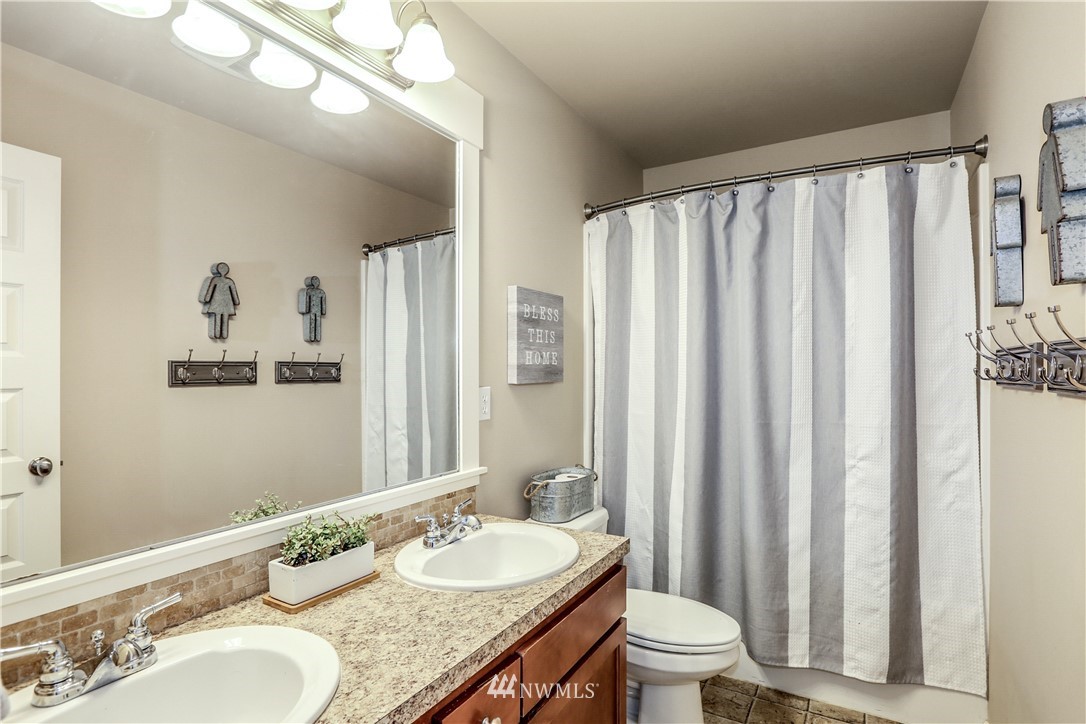 22505 38th Avenue Southeast Bothell, WA 98021 - Photo 25 of 39 a bathroom with a granite countertop sink and a mirror a toilet
