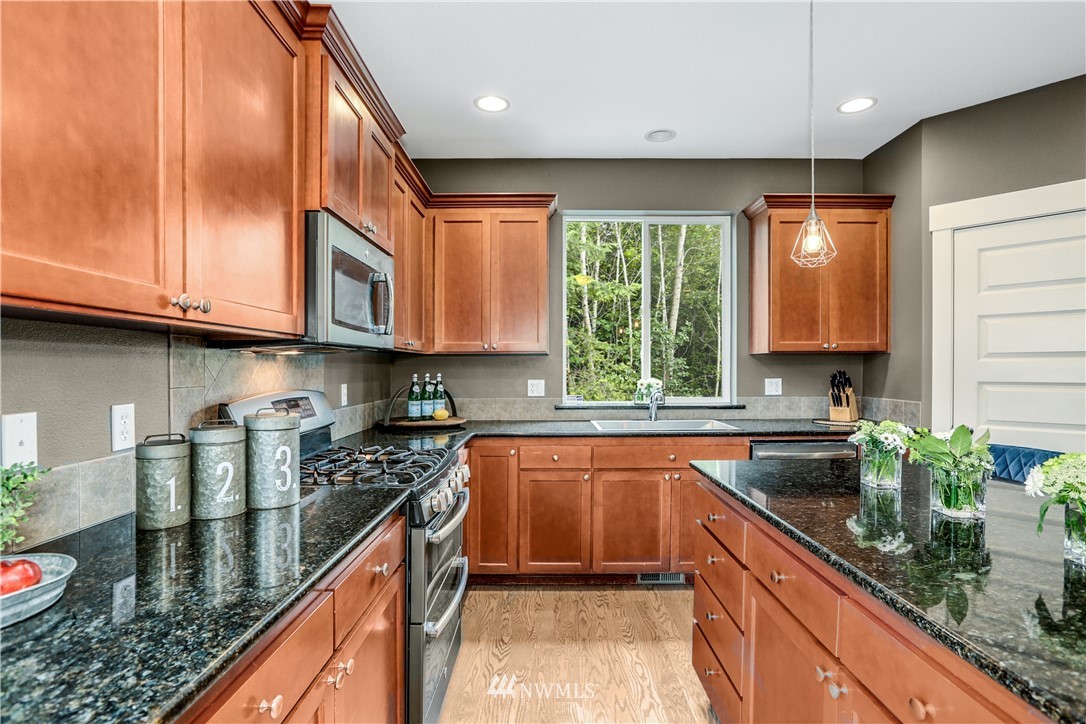 22505 38th Avenue Southeast Bothell, WA 98021 - Photo 8 of 39 a kitchen with stainless steel appliances granite countertop a sink a stove and cabinets