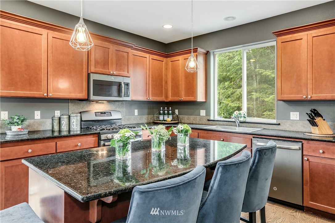 22505 38th Avenue Southeast Bothell, WA 98021 - Photo 10 of 39 a kitchen with stainless steel appliances granite countertop a stove a sink dishwasher a microwave oven with granite countertops and cabinets
