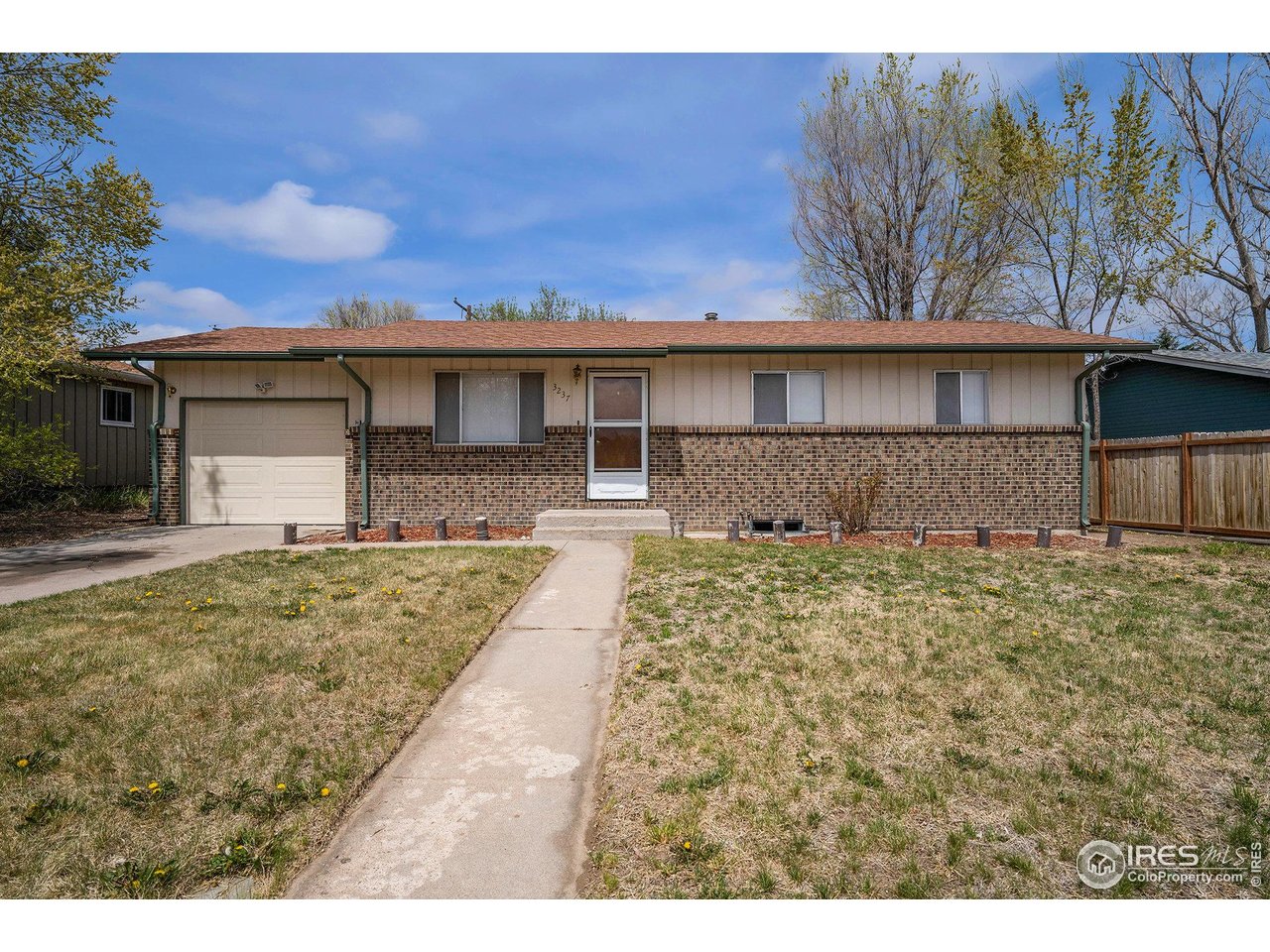 3237 West 5th St Road Greeley, CO 80634 - Photo 1 of 23 a front view of a house with a yard and garage