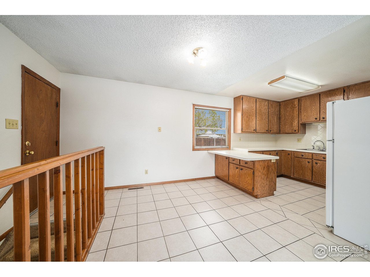 3237 West 5th St Road Greeley, CO 80634 - Photo 6 of 23 a large white kitchen with a sink a refrigerator and a stove