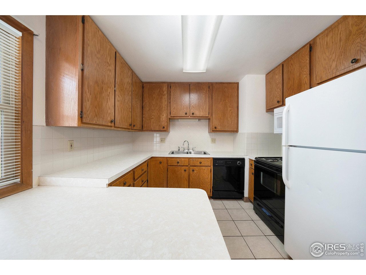 3237 West 5th St Road Greeley, CO 80634 - Photo 8 of 23 a kitchen with a refrigerator a stove top oven a sink and cabinets