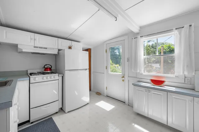 a kitchen with white cabinets and white appliances