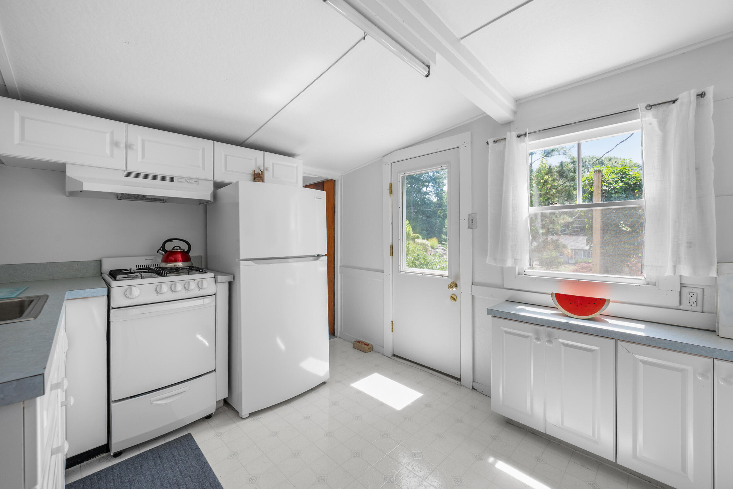62 Old Fish House Road South Dennis, MA 02660 - Photo 14 of 24 a kitchen with white cabinets and white appliances