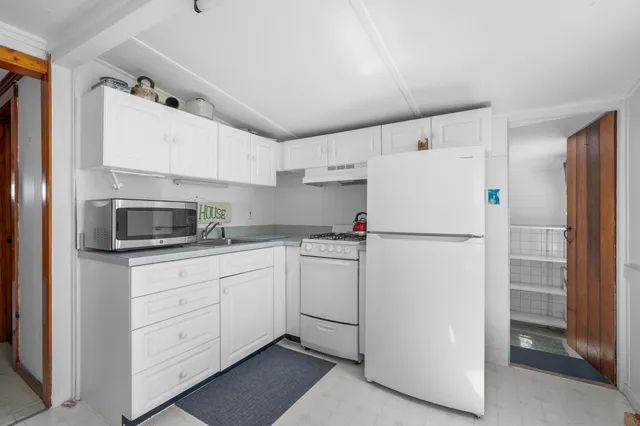 a kitchen with white cabinets and white appliances