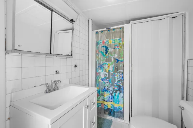 a bathroom with a sink a vanity and a shower curtain