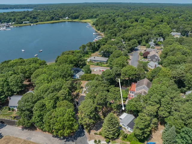 an aerial view of a house with a yard and lake view