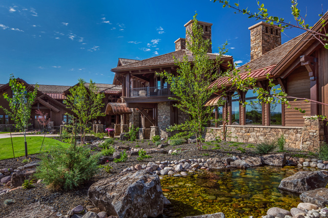 2322 North Westward Ho Road Heber City, UT 84036 - Photo 46 of 54 Back of house with a balcony, stone siding, a garden pond, and a chimney