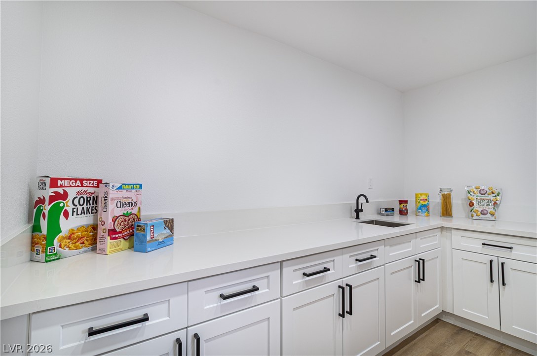 1891 Brian Road Pahrump, NV 89048 - Photo 11 of 50 Kitchen featuring white cabinetry, light countertops, light wood-type flooring, and a sink