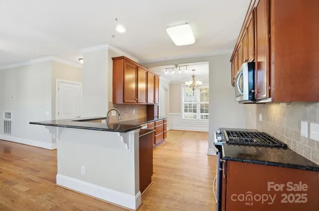 a kitchen with stainless steel appliances granite countertop a sink stove and cabinets