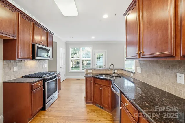 a kitchen with granite countertop stainless steel appliances and sink