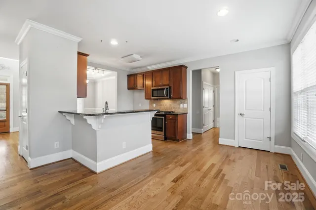 a kitchen with wooden floors and stainless steel appliances