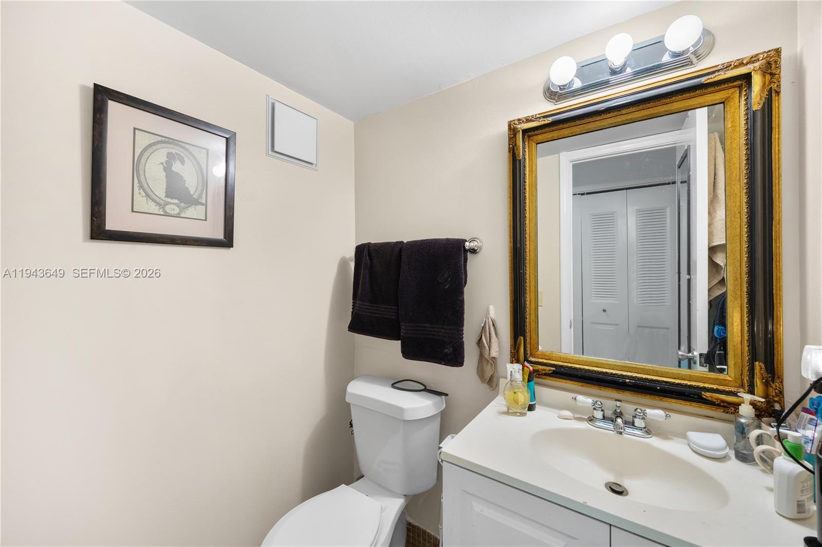 446 Durham O, Unit 446 Deerfield Beach, FL 33442 - Photo 12 of 26 a bathroom with a toilet sink vanity and mirror