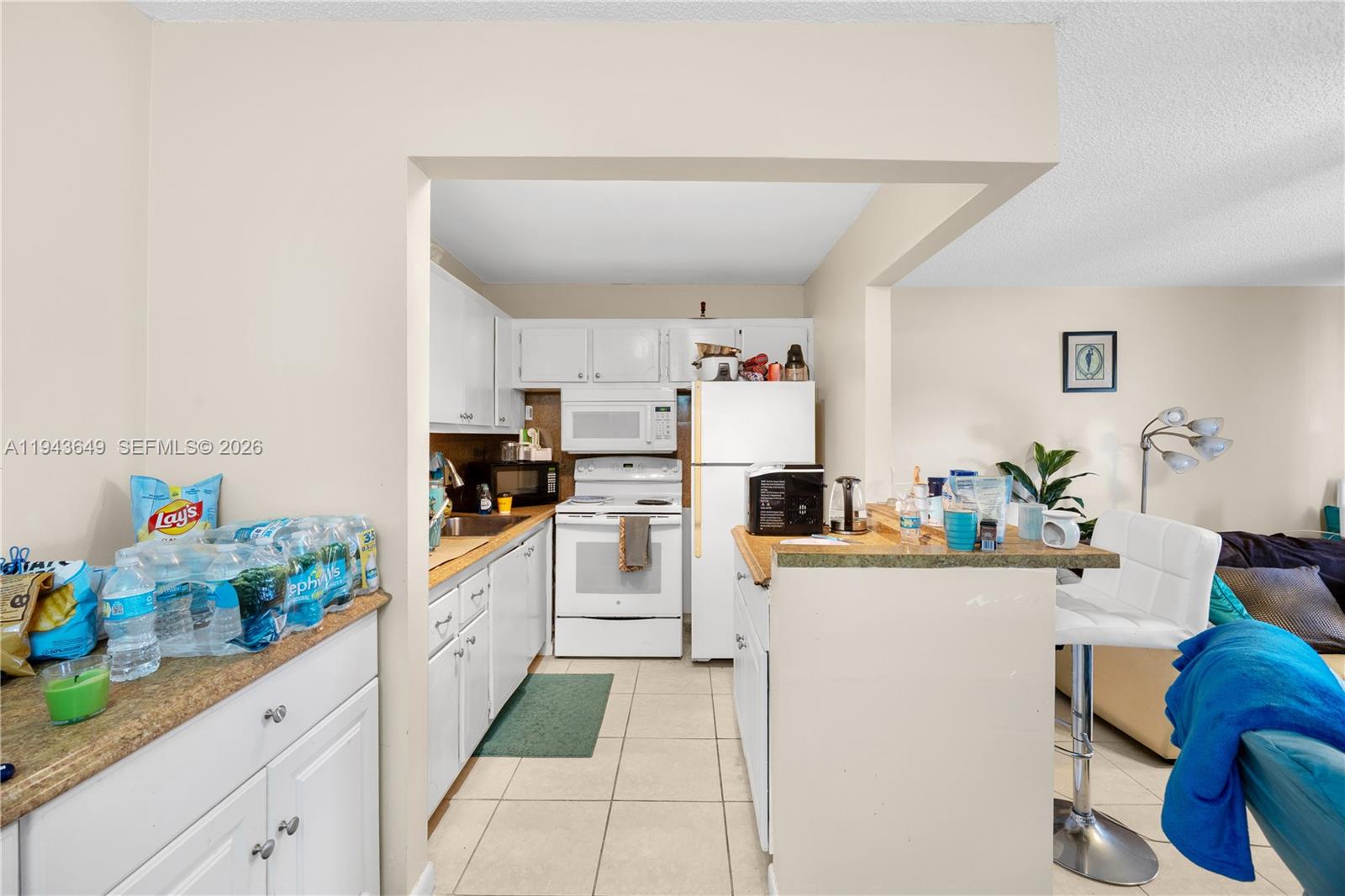 446 Durham O, Unit 446 Deerfield Beach, FL 33442 - Photo 5 of 26 a kitchen with a refrigerator a stove and white cabinets