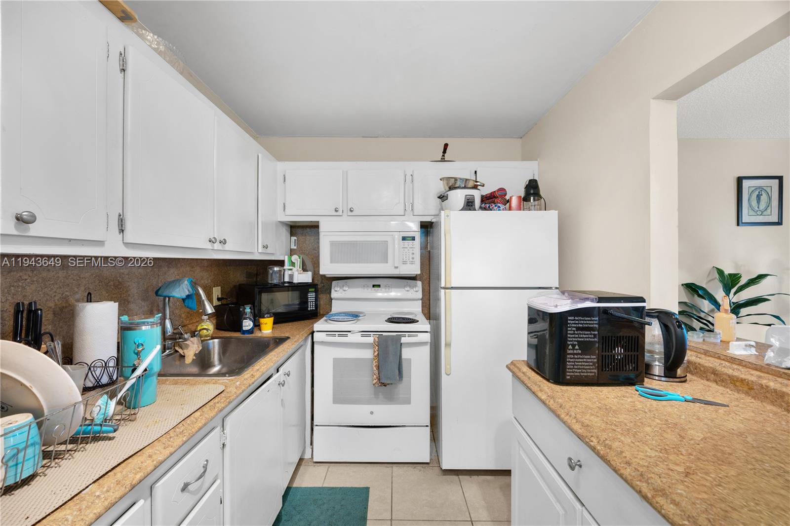 446 Durham O, Unit 446 Deerfield Beach, FL 33442 - Photo 7 of 26 a kitchen with white cabinets and white appliances