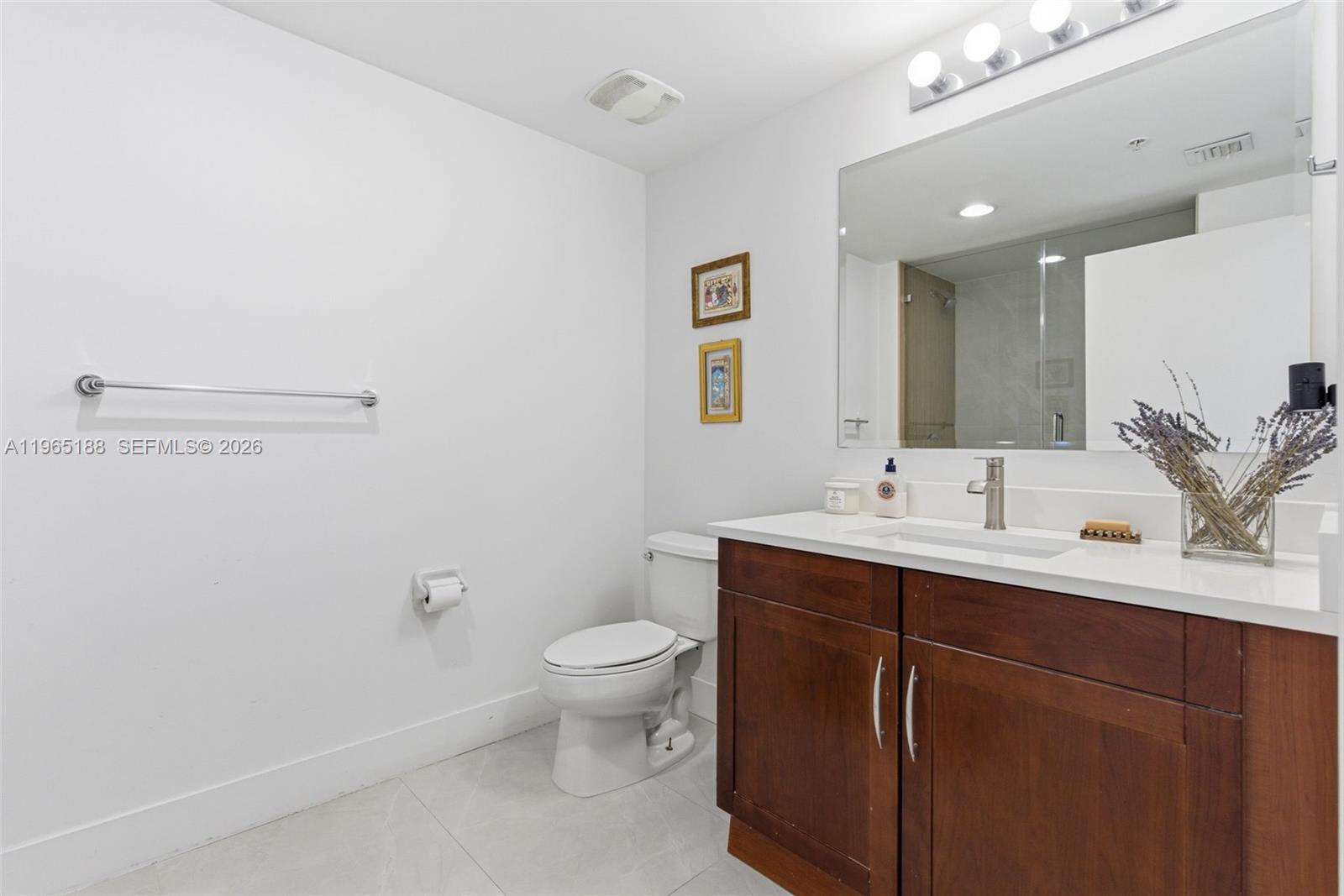7290 Southwest 90th Street, Unit 209 Miami, FL 33156 - Photo 32 of 40 a bathroom with a toilet a sink and mirror