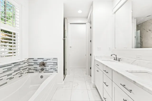 a bathroom with a tub sink and mirror