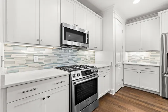 a kitchen with stainless steel appliances white cabinets and stove