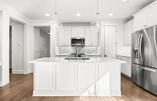 a kitchen with kitchen island a sink stainless steel appliances and cabinets
