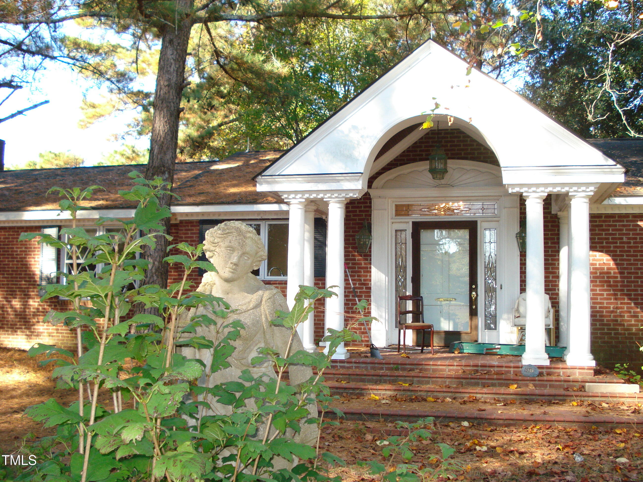 6349 Elevation Road Benson, NC 27504 - Photo 42 of 66 a view of a house with brick walls and floor to ceiling windows
