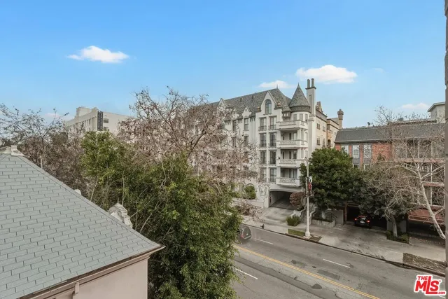 a kitchen with stainless steel appliances kitchen island granite countertop a stove a sink a refrigerator and white cabinets with wooden floor