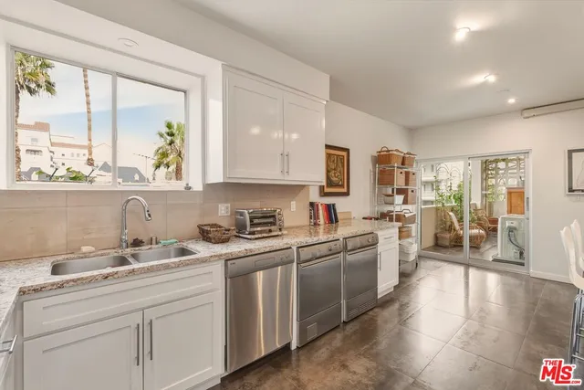 a large kitchen with lots of counter space a sink appliances and cabinets