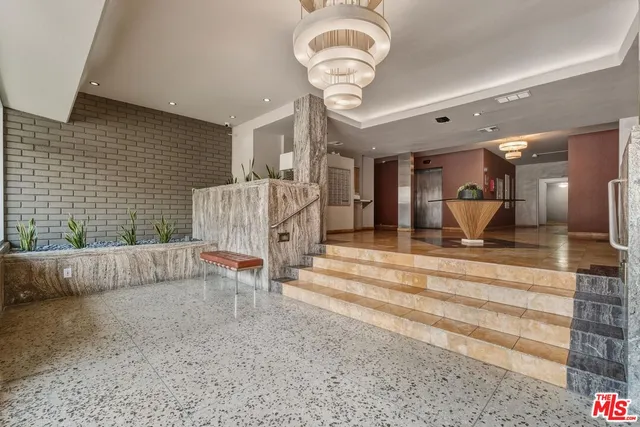 a view of a livingroom with a fireplace a chandelier and couch