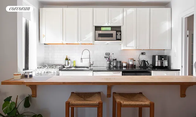 a kitchen with stainless steel appliances granite countertop a sink a stove and microwave