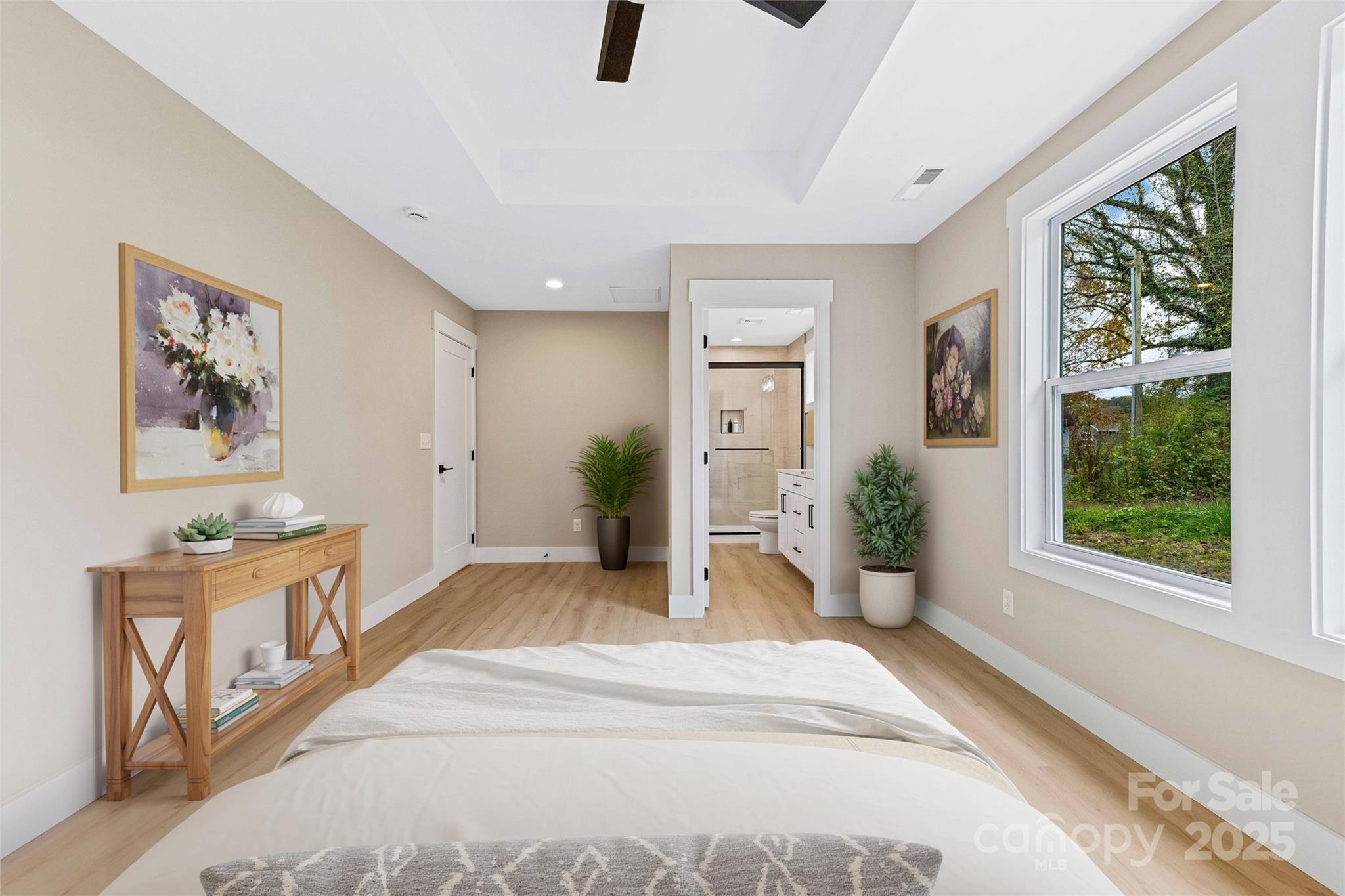 775 Olivette Road Asheville, NC 28804 - Photo 31 of 45 a spacious bedroom with a large bed and a chandelier