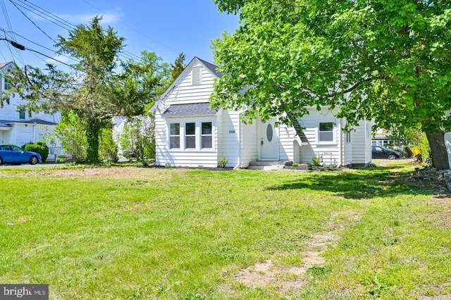 a view of house with backyard and trees