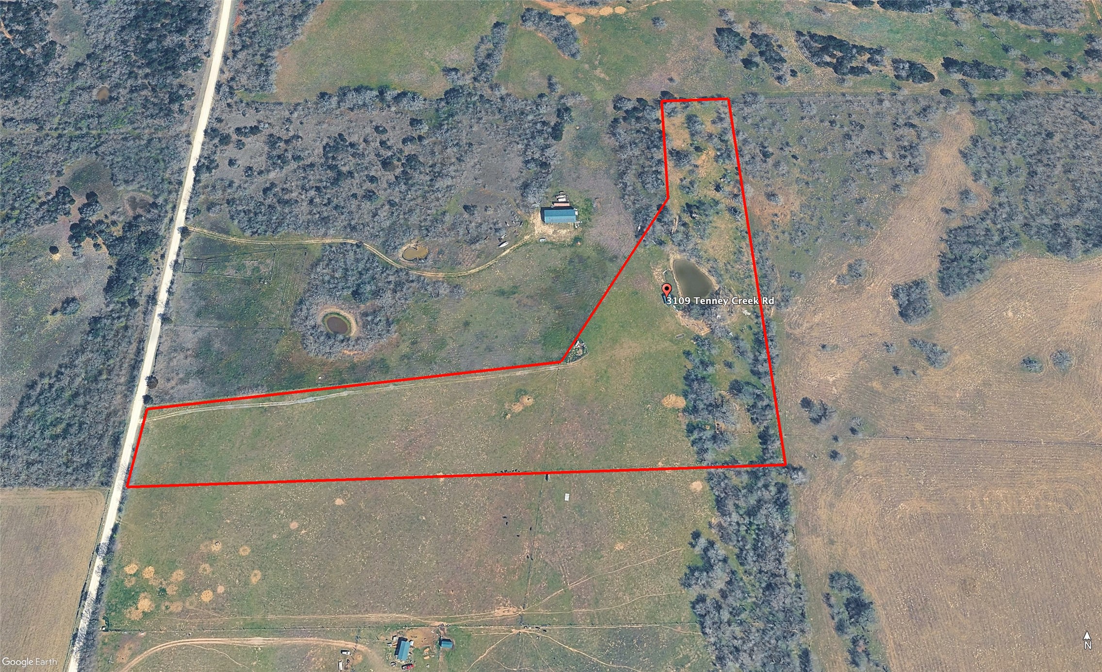 3109 Tenney Creek Road Dale, TX 78616 - Photo 7 of 23 A sweeping aerial view reveals a vast rural property featuring a prominent pond and ample open pastureland.