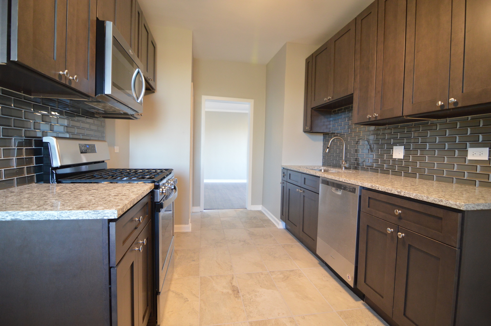 3422 West Grenshaw Street, Unit 2 Chicago, IL 60624 - Photo 12 of 12 a kitchen with granite countertop a sink a stove and cabinets