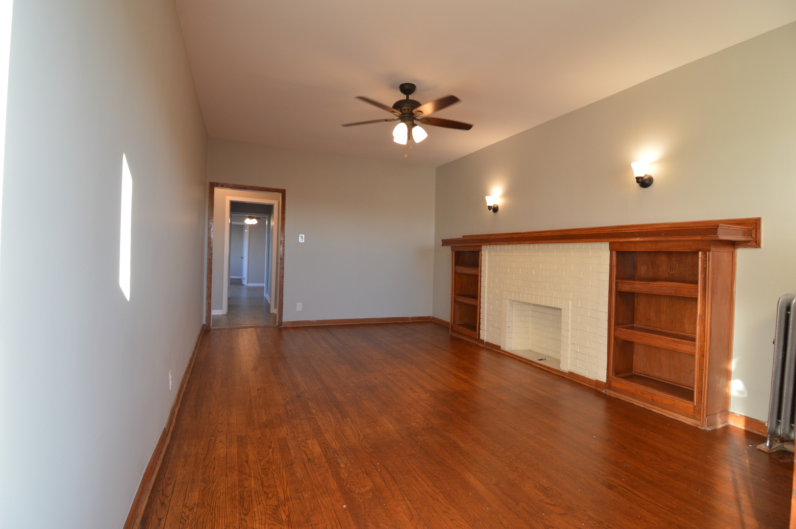3422 West Grenshaw Street, Unit 2 Chicago, IL 60624 - Photo 2 of 12 a view of a livingroom with wooden floor a ceiling fan and windows