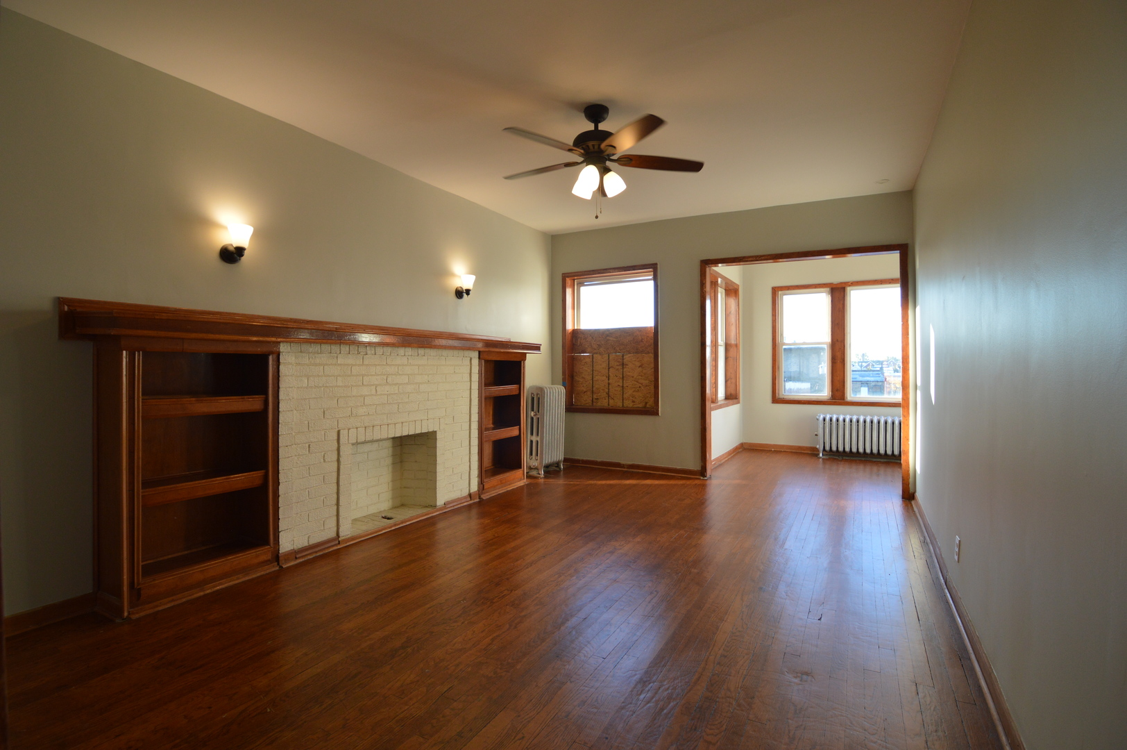 3422 West Grenshaw Street, Unit 2 Chicago, IL 60624 - Photo 4 of 12 an empty room with wooden floor fireplace and windows