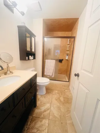 a bathroom with a sink a toilet and shower