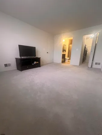 an empty room with furniture and natural light