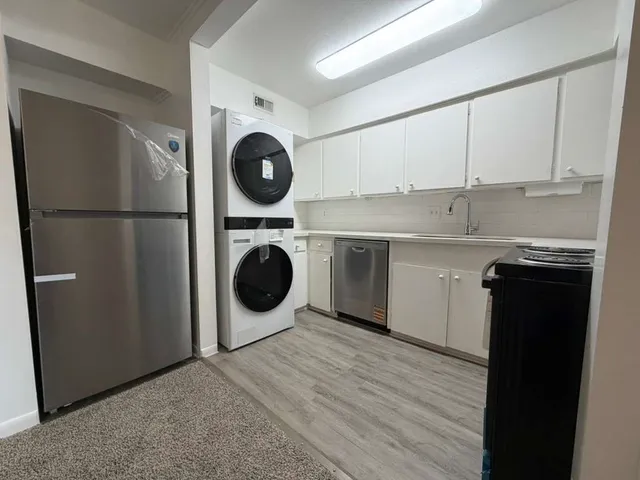 a kitchen with a refrigerator sink and cabinets