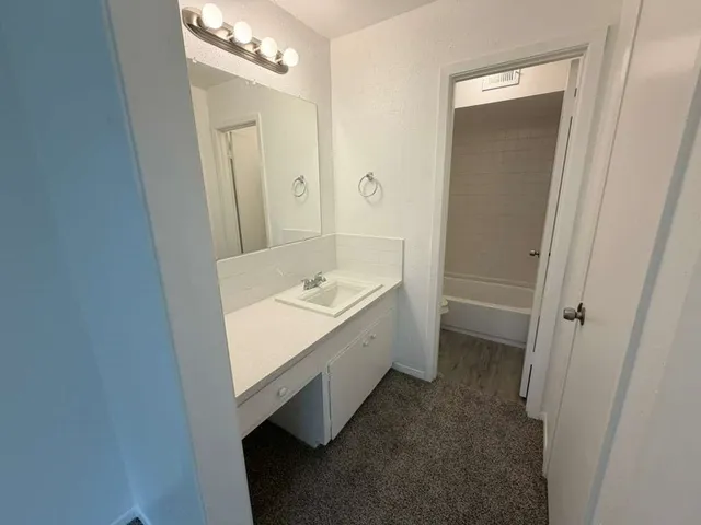 a bathroom with a sink a tub and a mirror