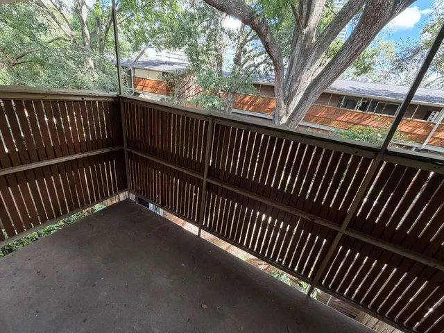 a view of balcony with wooden floor and fence