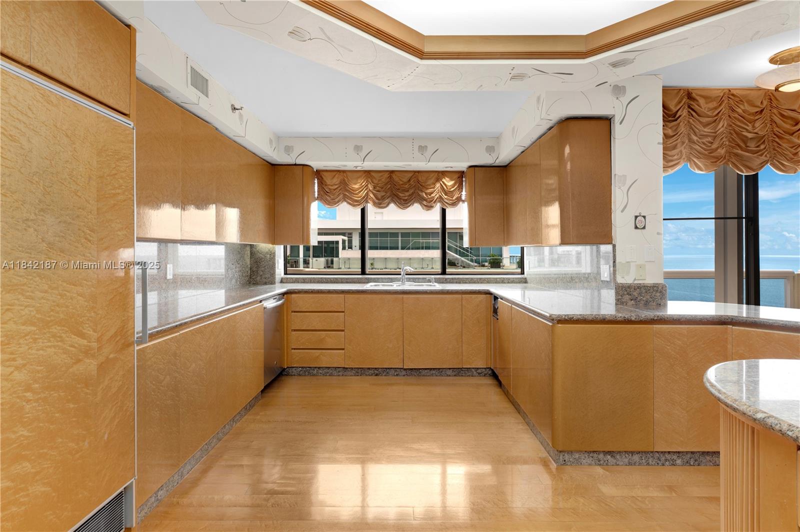 5757 Collins Avenue, Unit PH4 Miami Beach, FL 33140 - Photo 15 of 27 a large white kitchen with a large window