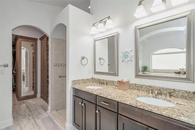 a living room with stainless steel appliances kitchen island a table chairs and a refrigerator