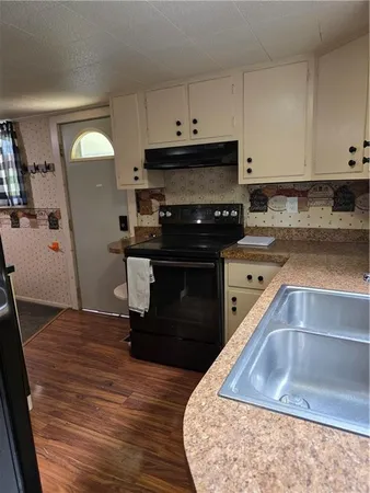 a kitchen with a sink and a stove top oven