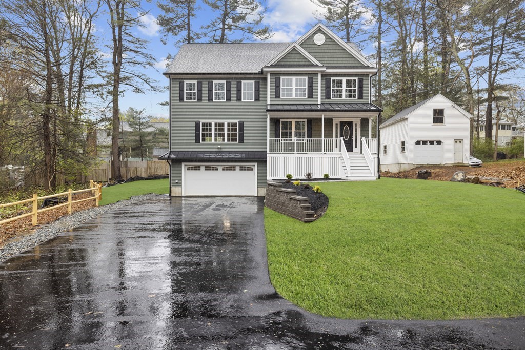 a view of a white house with a yard yard and large tree