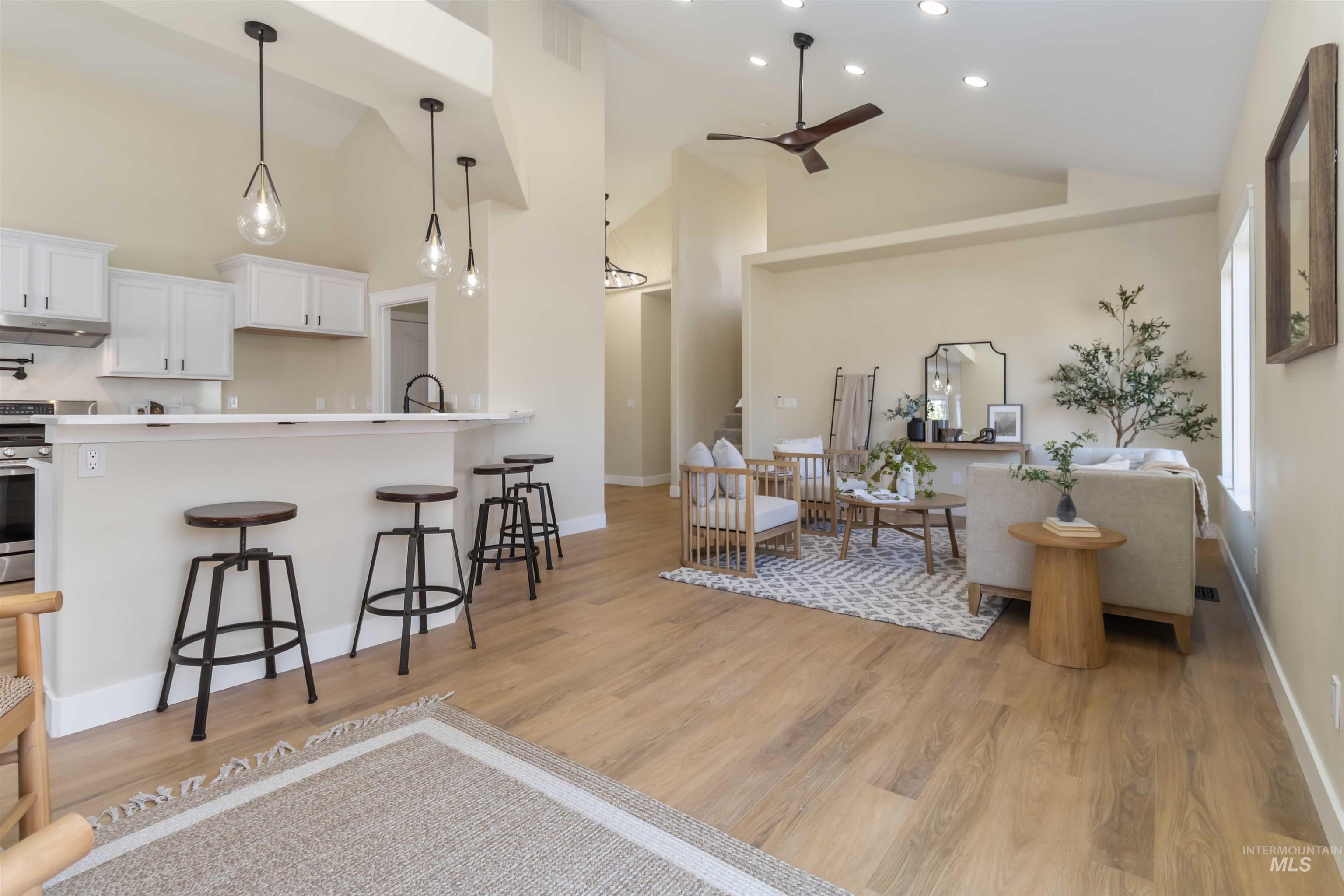 3201 Raintree Drive Nampa, ID 83686 - Photo 50 of 50 Kitchen with a breakfast bar area, white cabinetry, open floor plan, ceiling fan, and pendant lighting