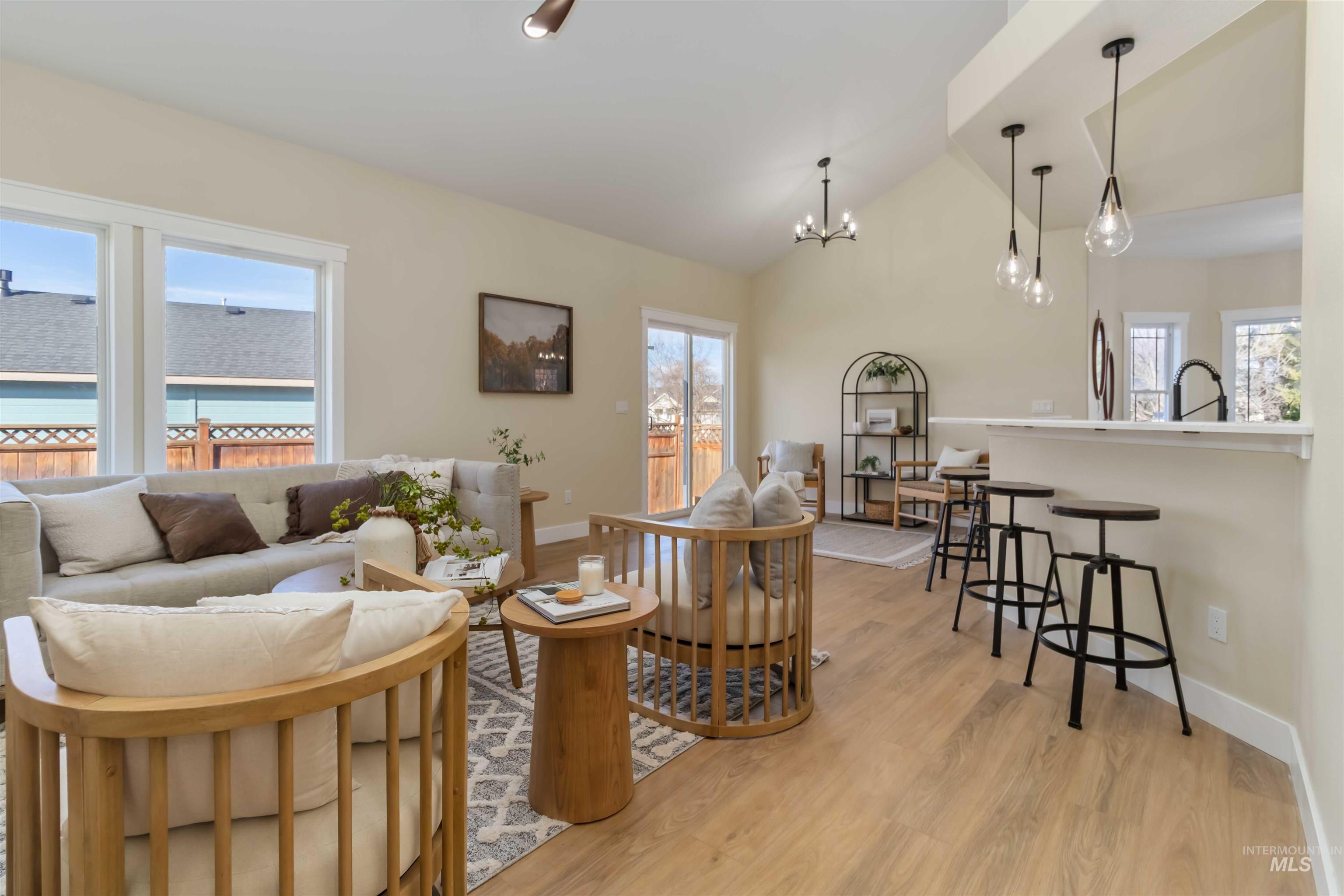 3201 Raintree Drive Nampa, ID 83686 - Photo 13 of 50 Living area featuring healthy amount of natural light, light wood-style floors, vaulted ceiling, and a chandelier