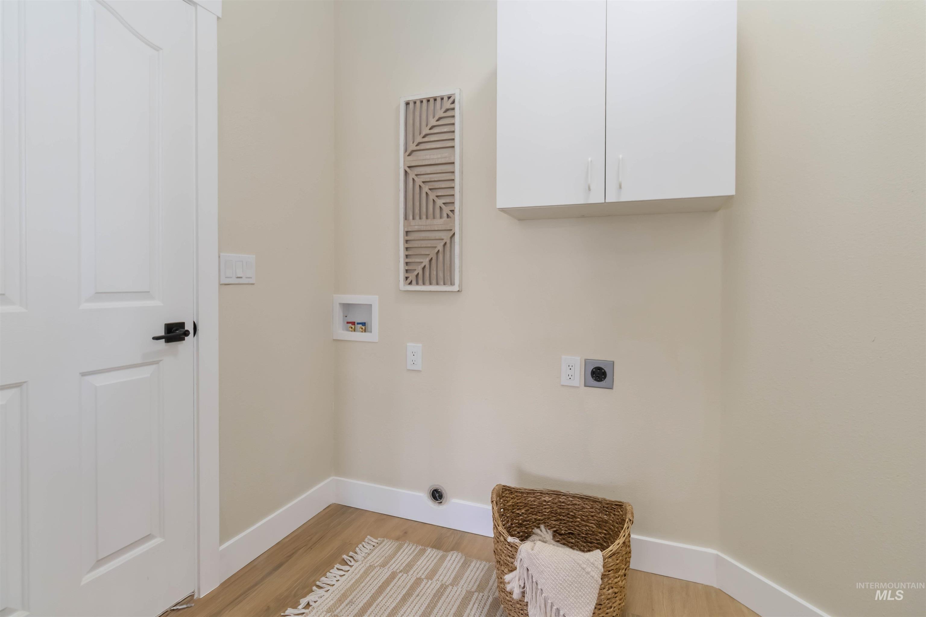 3201 Raintree Drive Nampa, ID 83686 - Photo 27 of 50 Laundry room featuring cabinet space, electric dryer hookup, washer hookup, and light wood finished floors